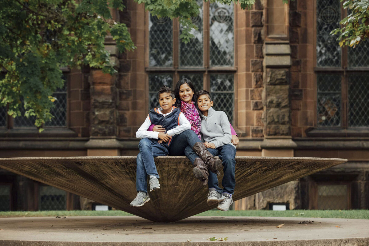 Family Photographer | Mother and two sons posing together among fall leaves on the Princeton University campus | Princeton, New Jersey