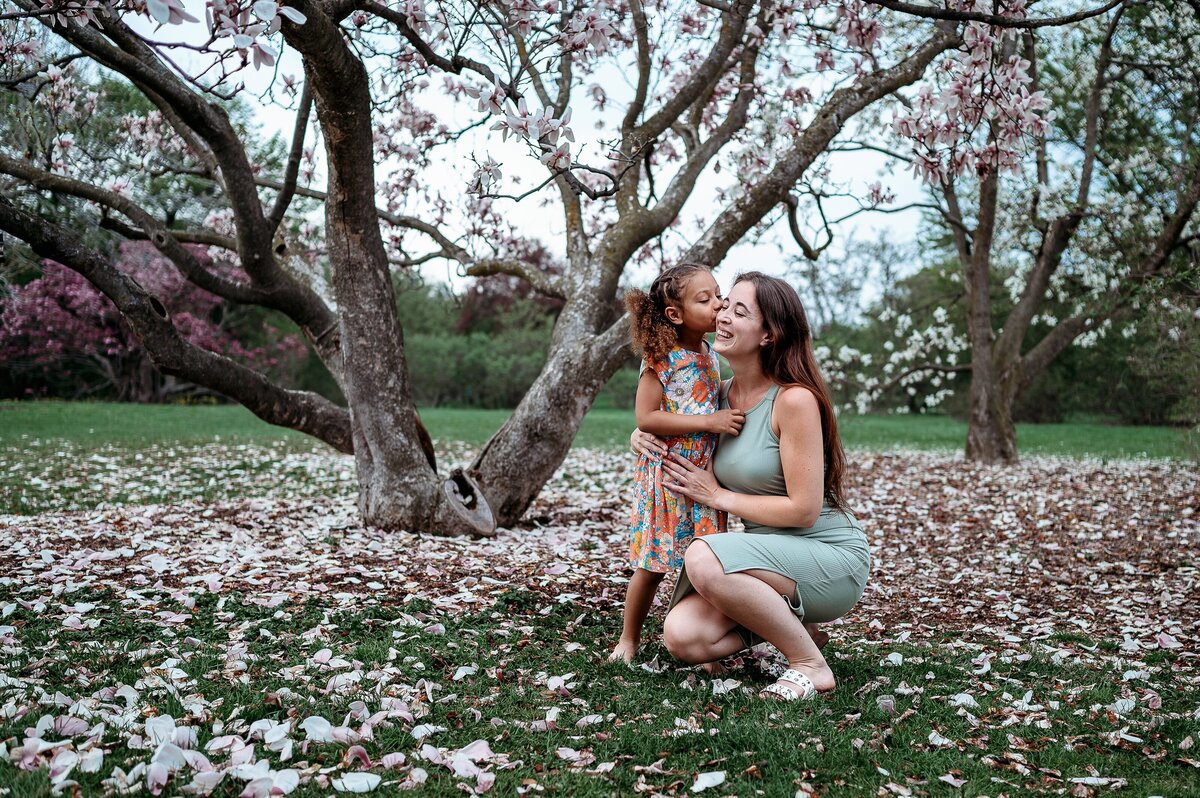 Mother and child in magnolia petals McKennaPattersonPhotography