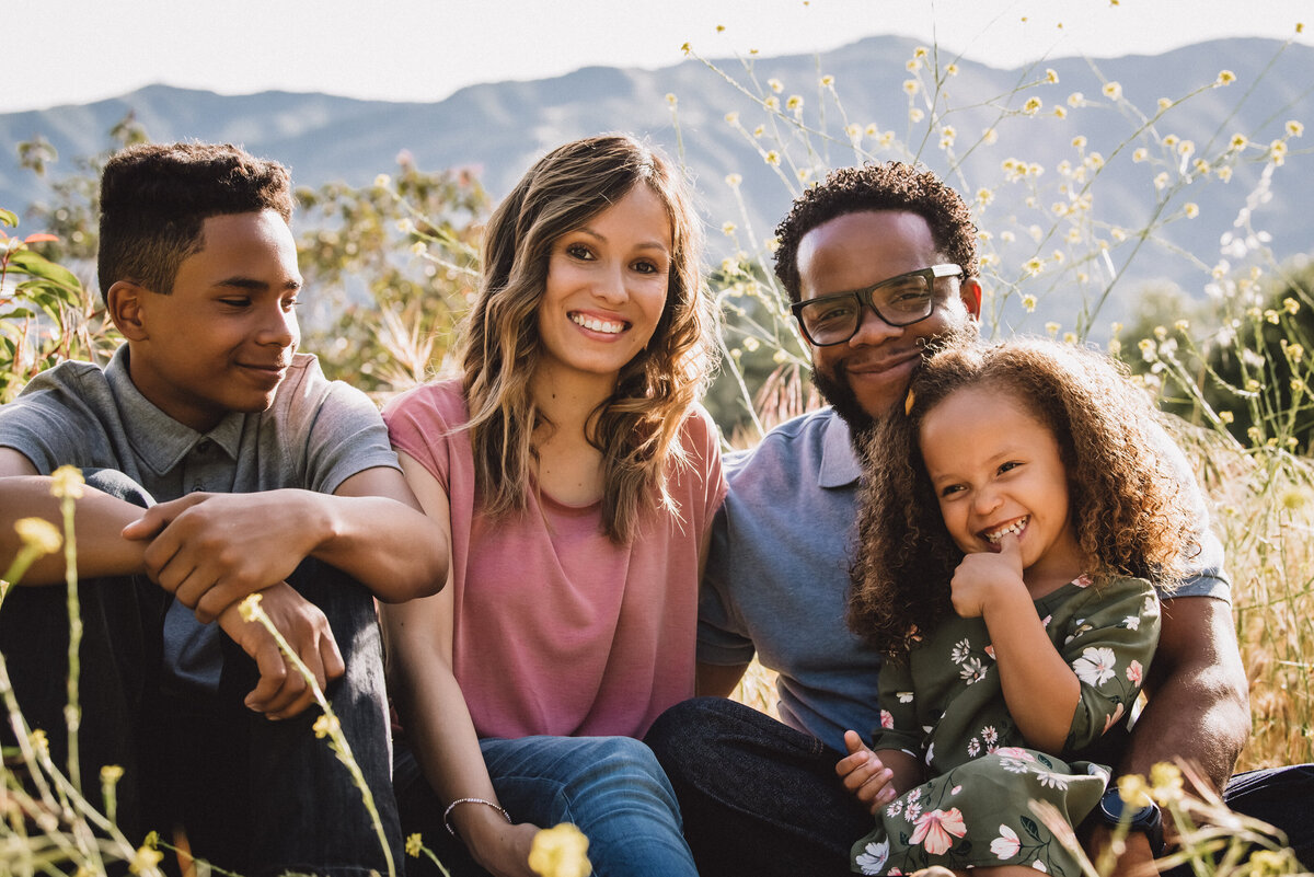 Mixed race family of four pose on La Canada hillside