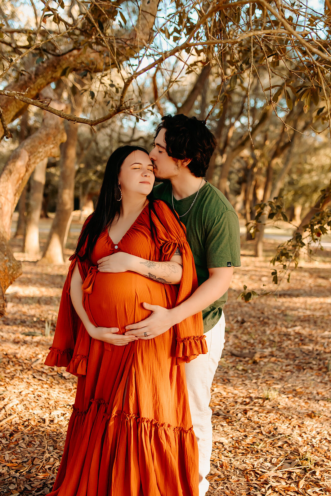 Romantic maternity session in Cleveland TX with expecting couple, husband kissing wife outdoors