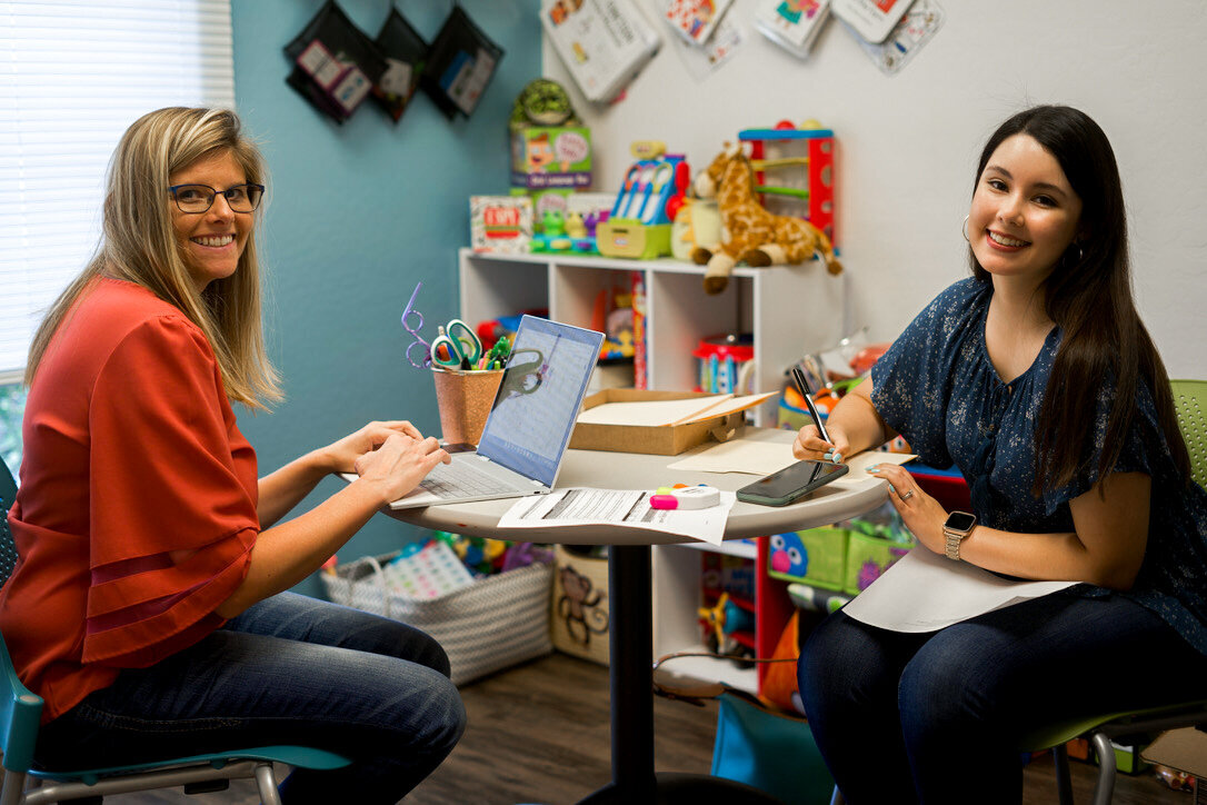 two happy speech therapists at the desk