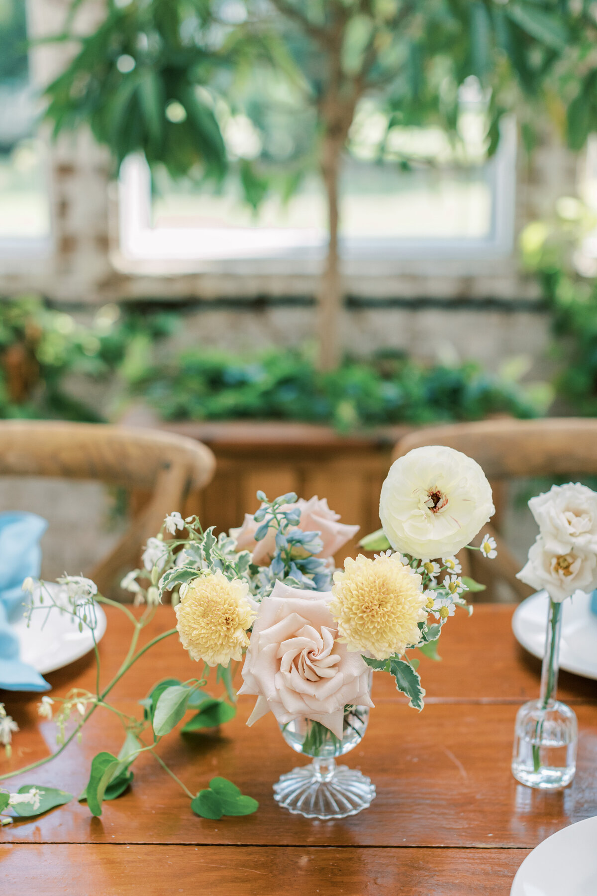 A pastel floral centerpiece sits on the wooden table.