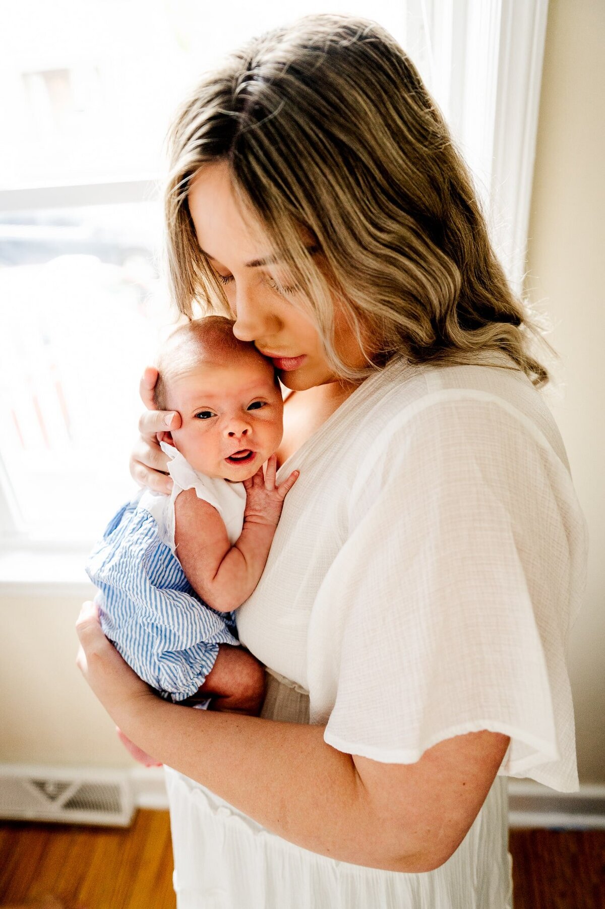 mom holding a baby girl while kissing her