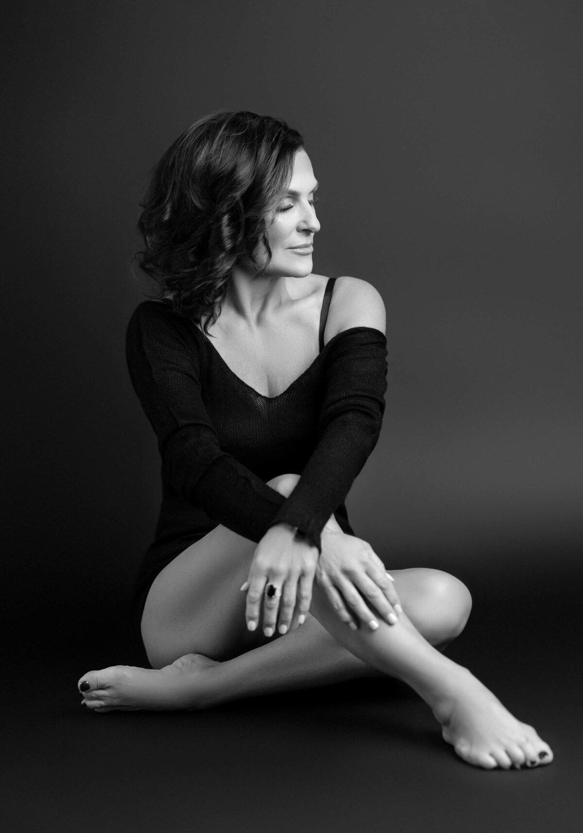 Elegant black and white boudoir portrait of a confident woman.