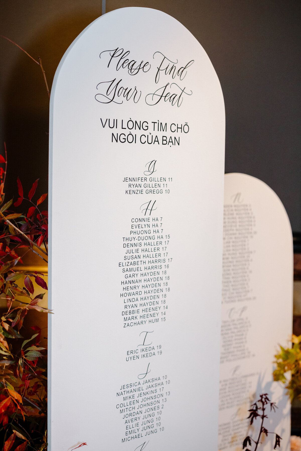 Close up of arched seating chart panel with calligraphy and lettering
