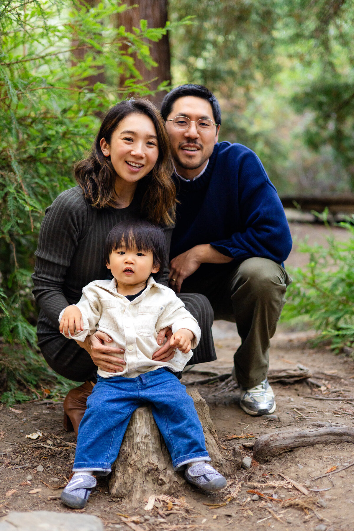 Family portrait with parents and toddler sitting on a tree stump in the woods – Bay Area Family Portfolio | Ellobelle Photography