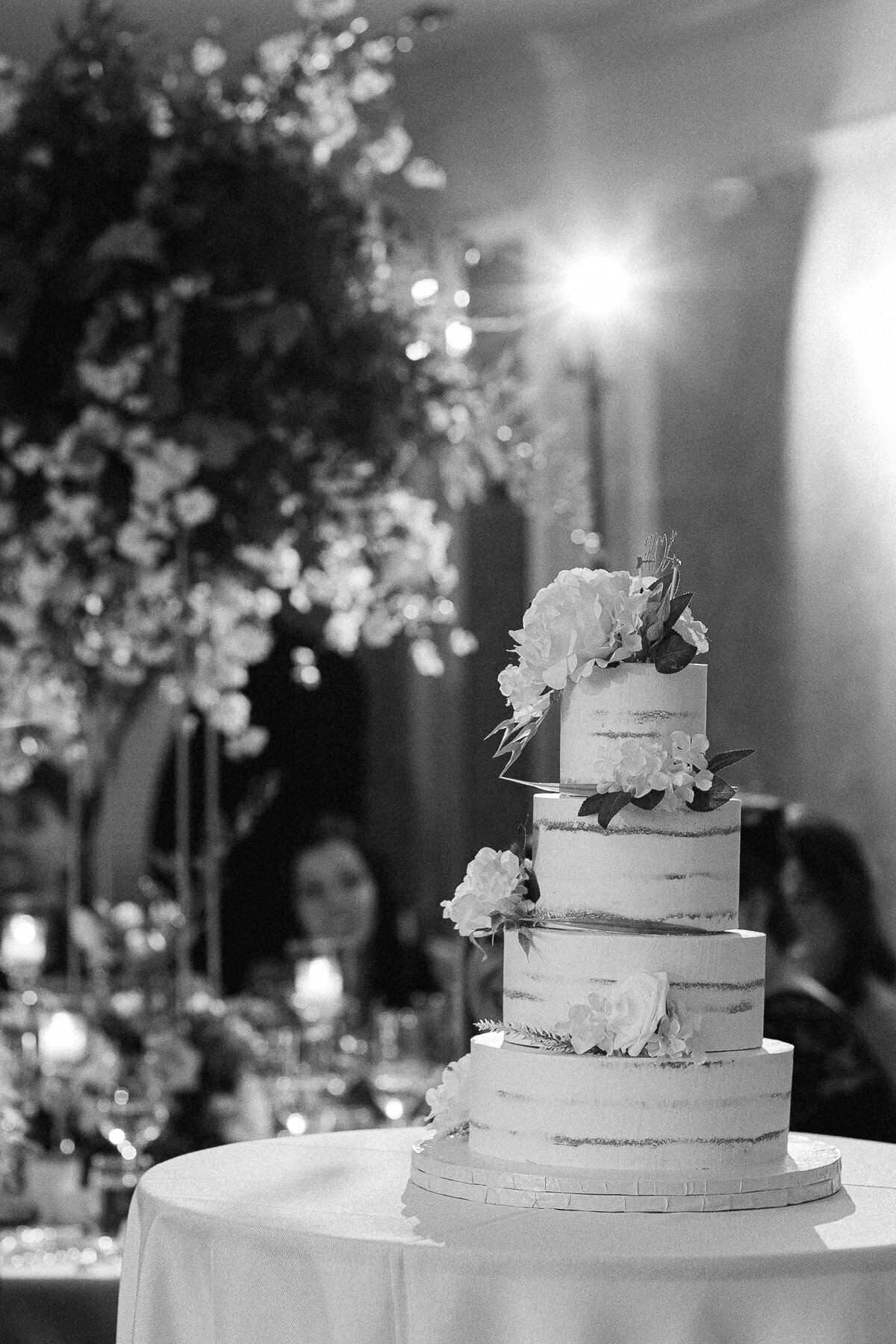 Gâteau de mariage à 4 étages avec de belles fleurs et une lumière magnifique. 