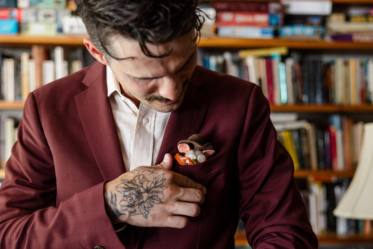 A person adjusting the boutonniere on their jacket
