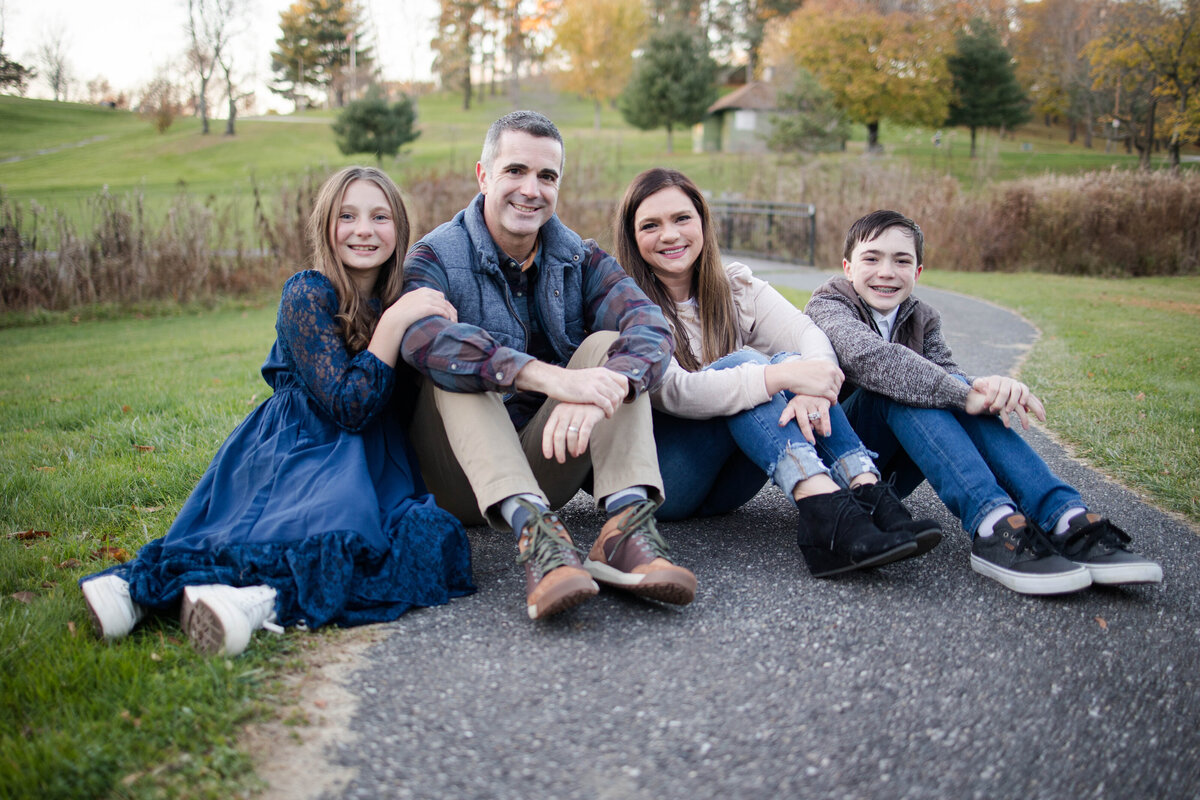 Family of four sitting together dressed in creams and blue colors