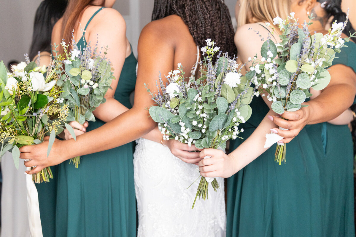 Bridesmaids hugging each other with their bouquets