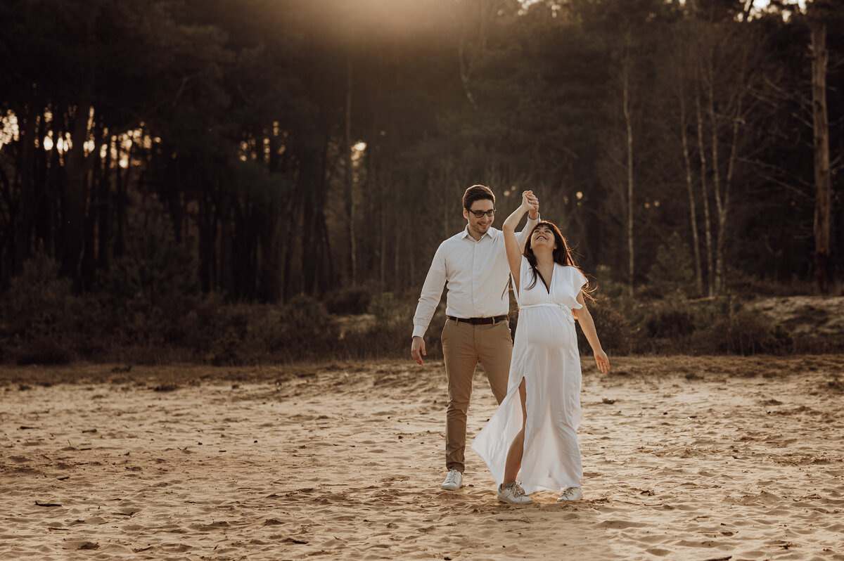 Koppel danst tijdens zwangerschapsshoot op de heide in Antwerpen