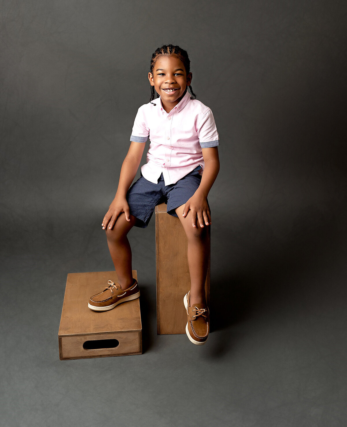 A boy with a contagious laughter, captured in a candid moment during a Brooklyn portrait session