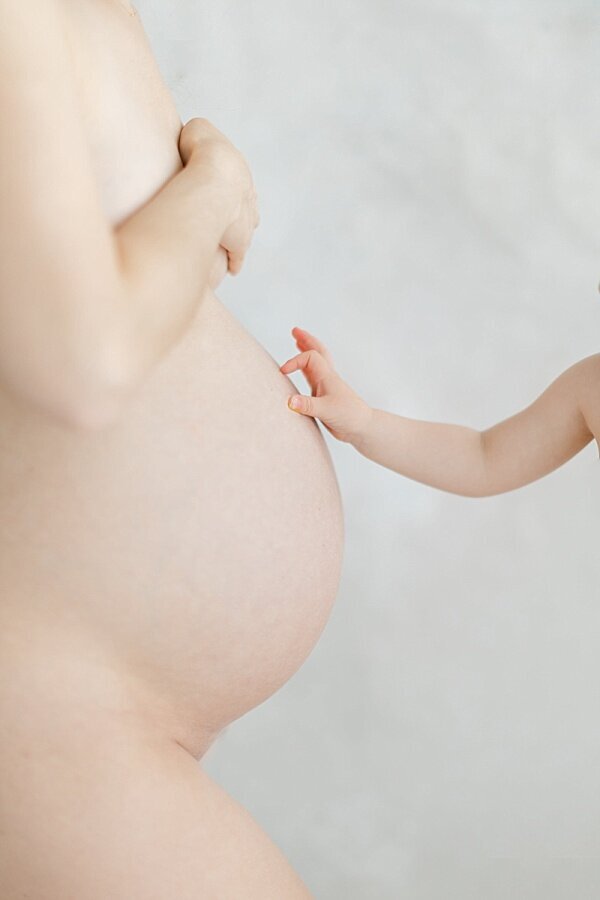 Baby reaches out to touch pregnant mama's belly