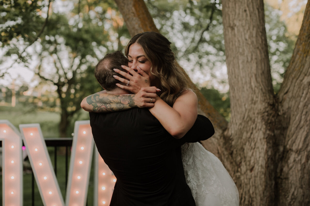 groom picking bride up with her laughing