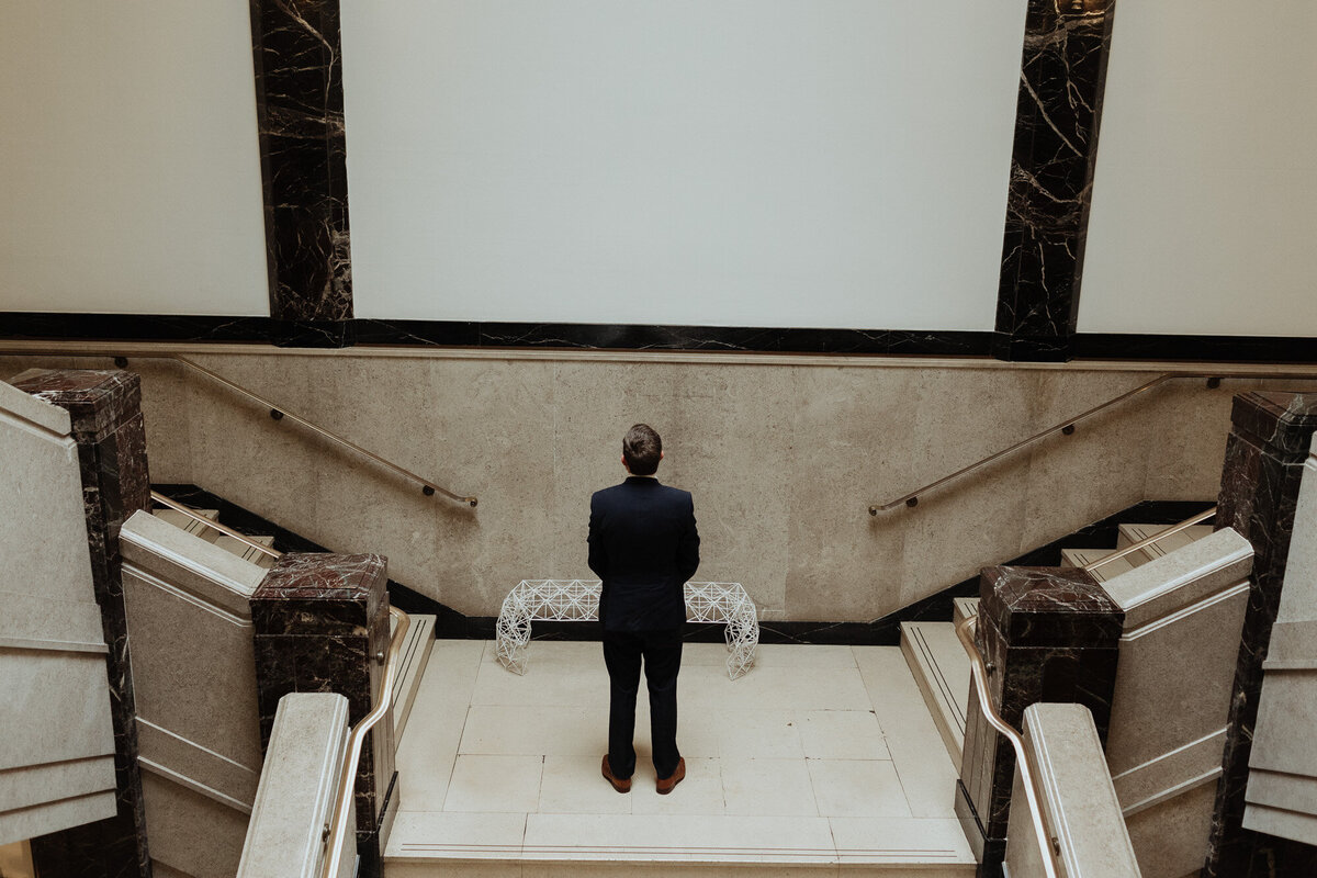 groom waiting at top of staircase