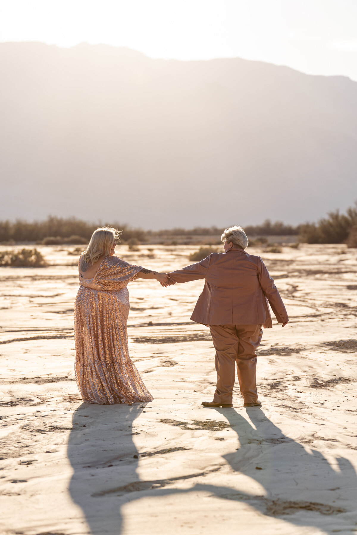 A couple reaching out for each other at golden hour