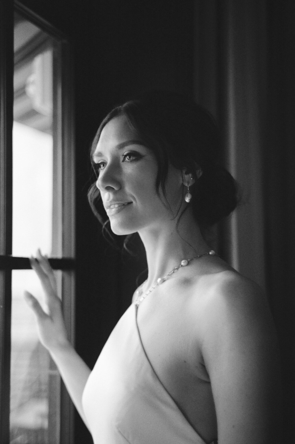 candid wedding photography at Shinola Hotel, soft black and white, bride gazes out window