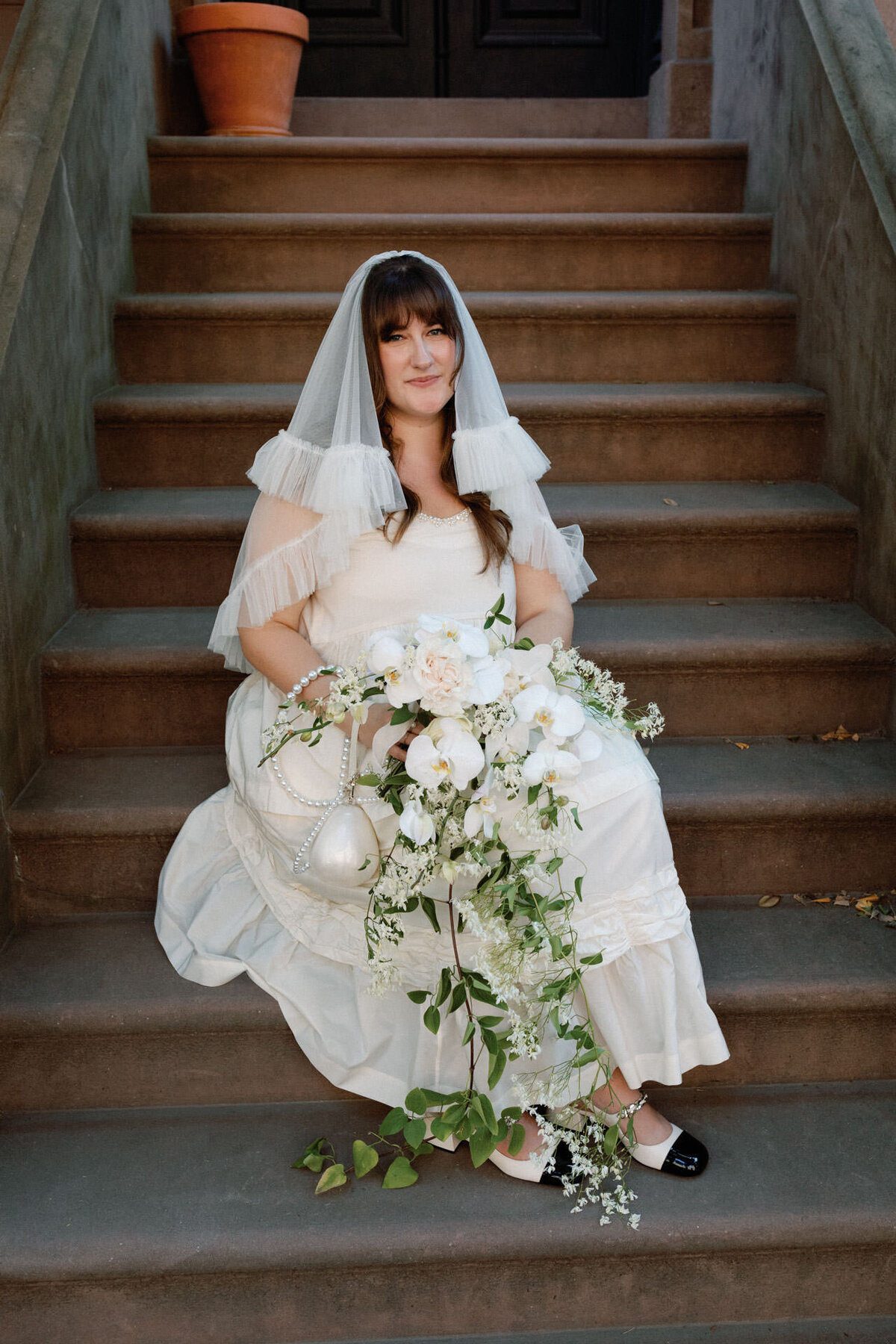 Brooklyn bride featured on the cut wedding files with cascading bouquet simone rocha dress molly goddard veil on stoop