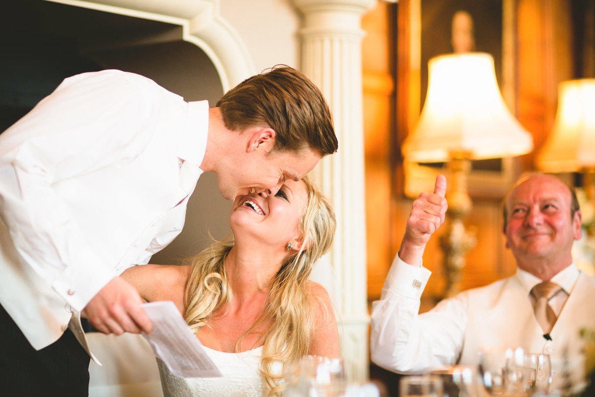 groom giving a speech and kissing the bride