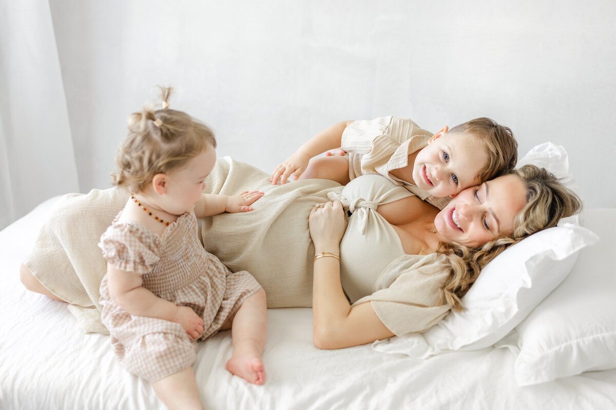 Classic and elegant studio maternity portrait of Katie and her children, captured in natural light in Tampa