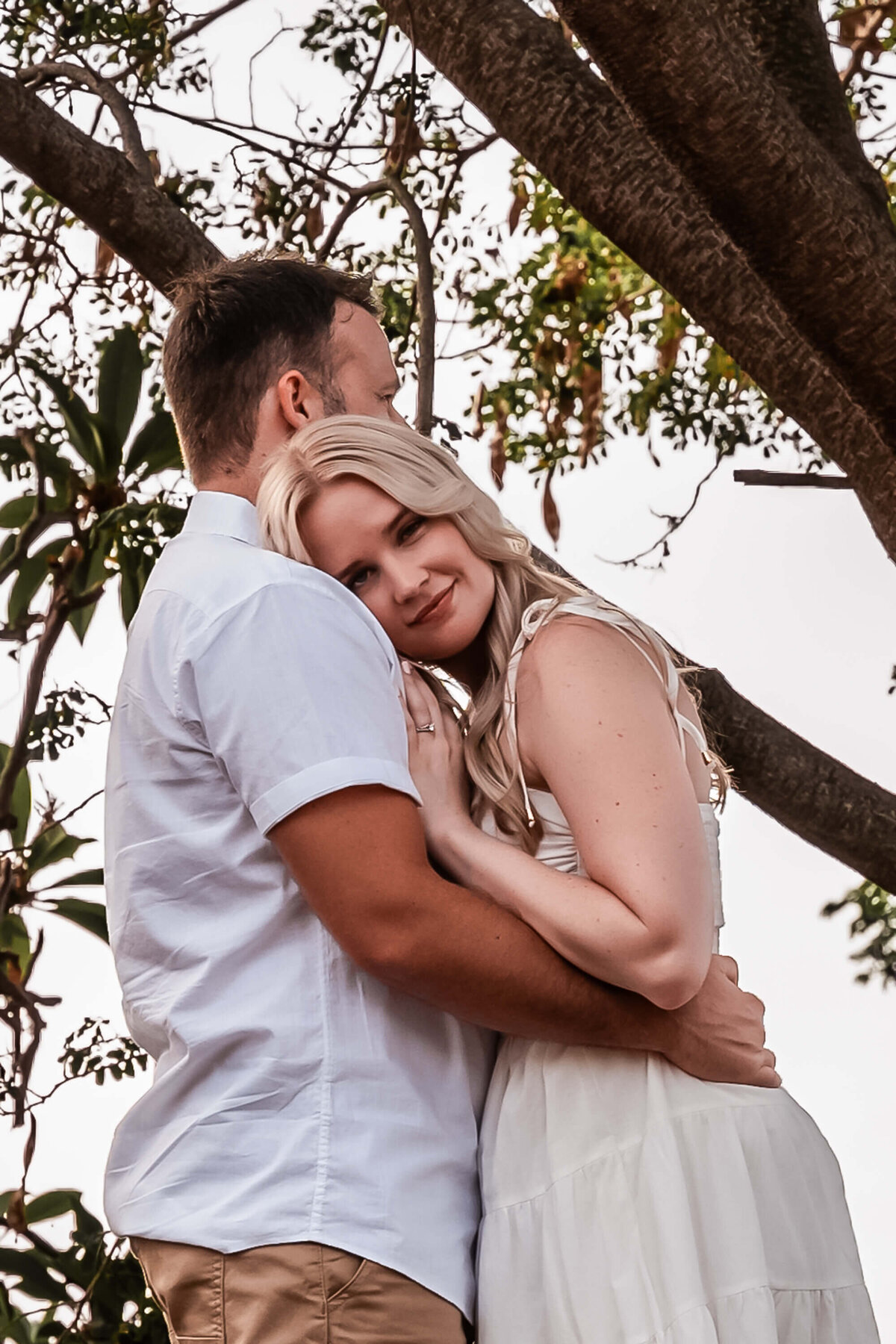 A couple in love smiles warmly at each other, beautifully captured by a Townsville engagement photographer. - photo by Jamie Simmons