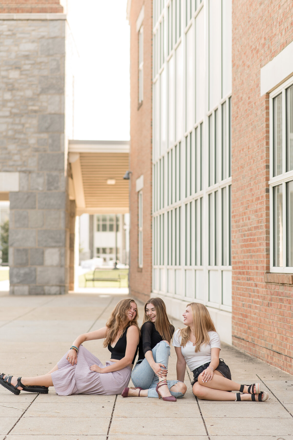 Three Senior girls sitting on sidewalk together at Founder's Hall in Hershey, Pennsylvania.
