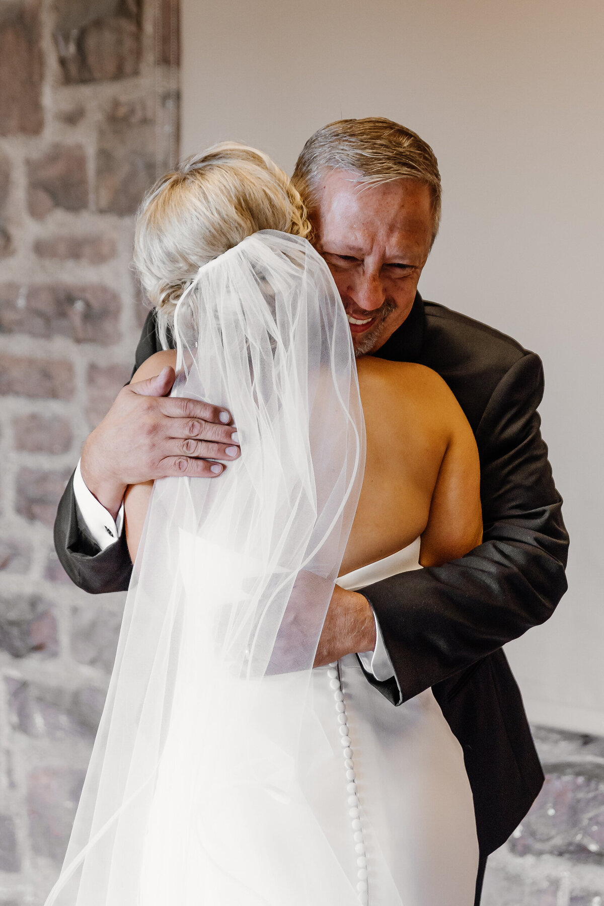 A person hugging a bride and crying