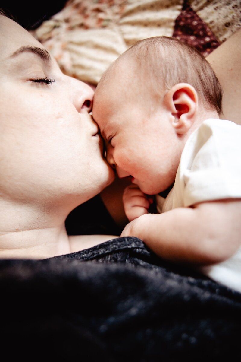 a newborn baby girl fast asleep next to her mom