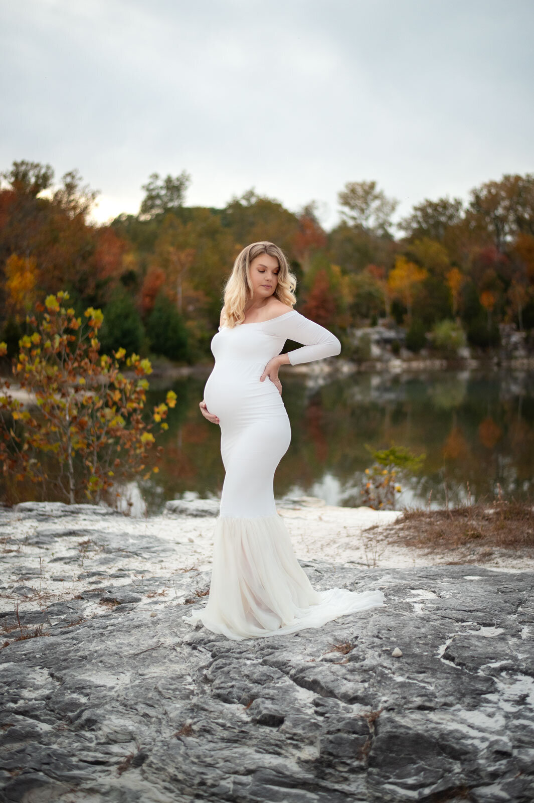 pregnant woman outside on rock in white gown