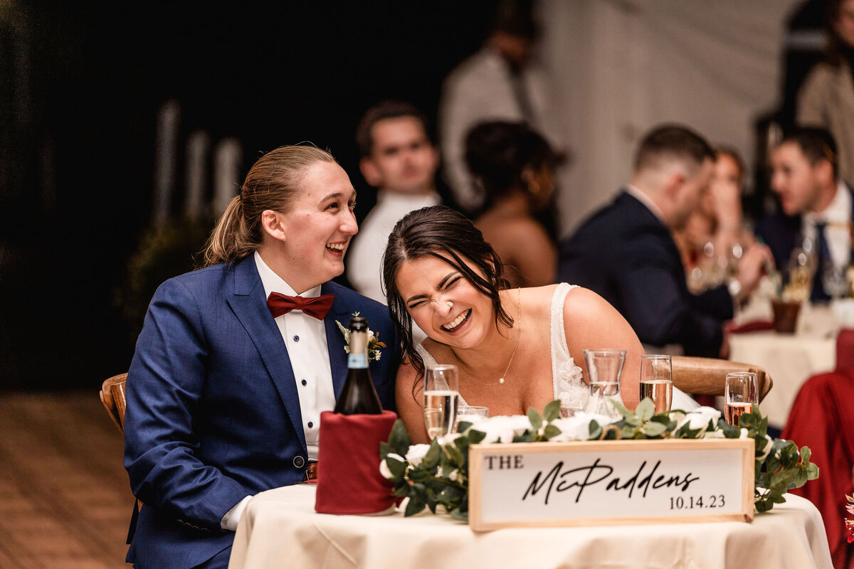 Bride laughing at sweet heart table during reception at Waterville Valley Resort wedding in New Hampshire by Lisa Smith Photography