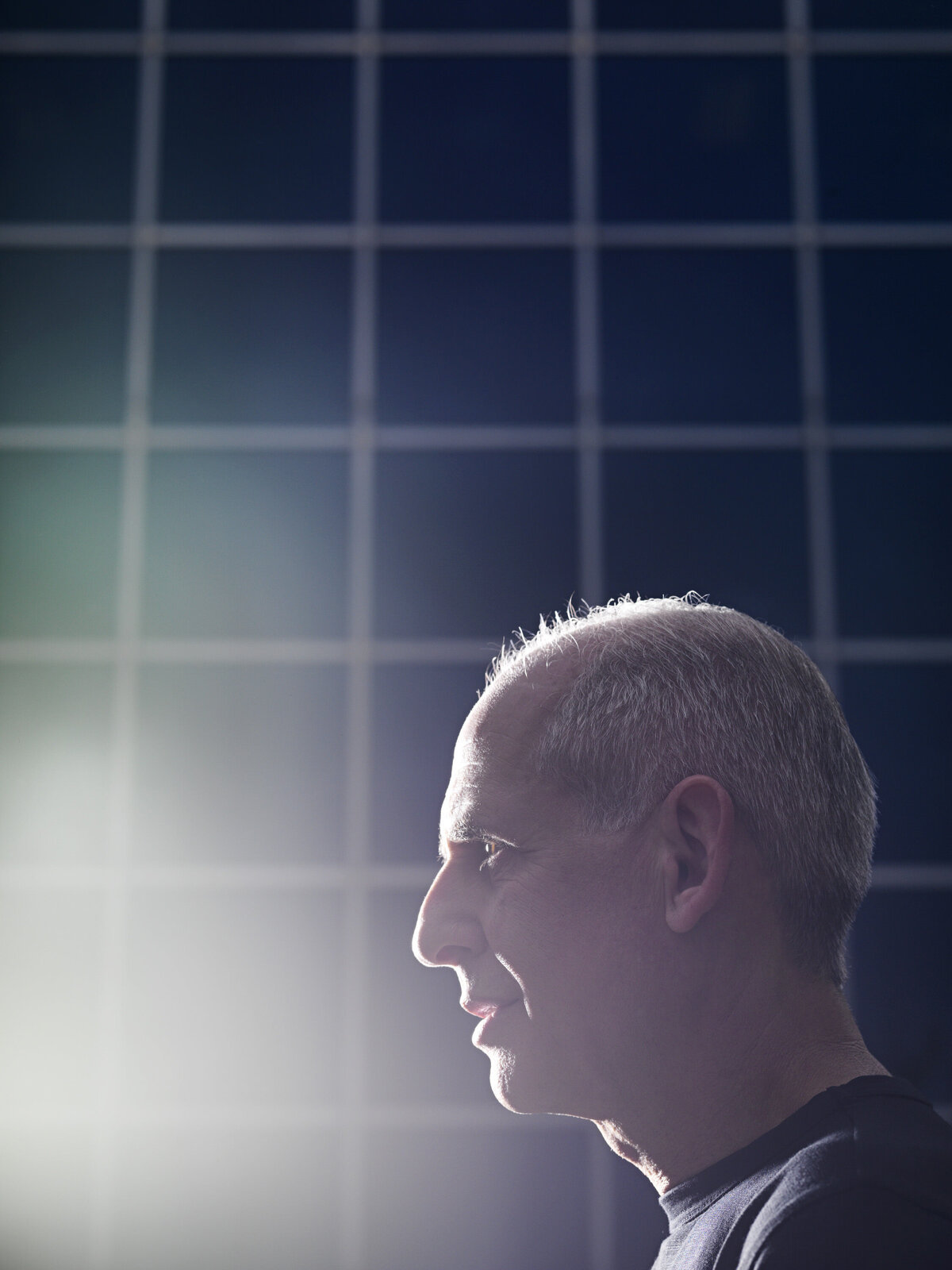 A man against a blue tiled background