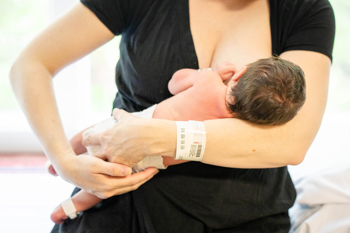 Raw and authentic moment of mother nursing newborn baby