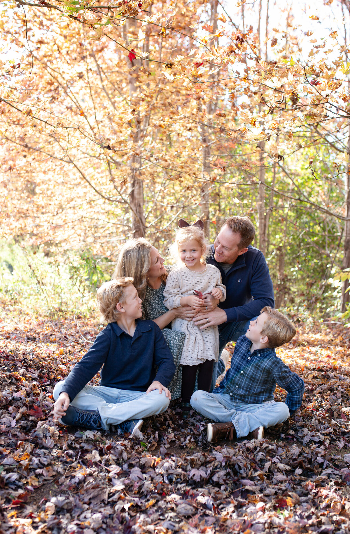 family of 5 enjoying their time together at a park  during fall in wake forest