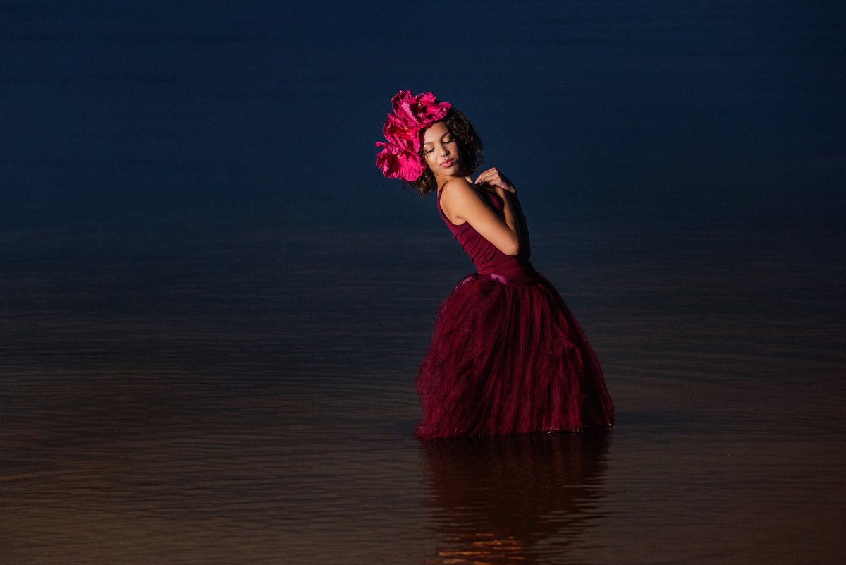 girl in prom dress with flowers in hair in lake