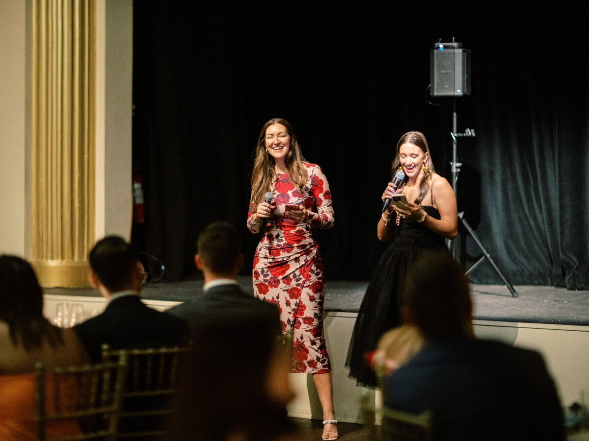 Two women share memories and toasts with the couple in a beautifully decorated venue with stylish guests seated.
