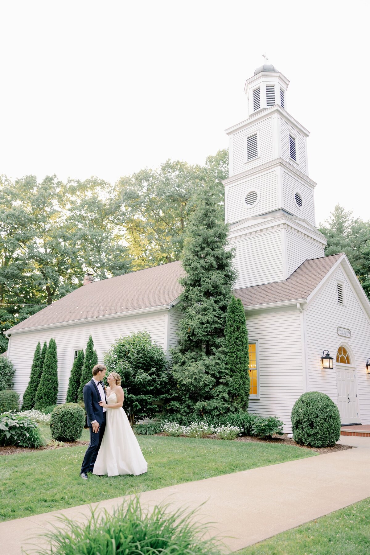 bride and groom smiling at each other outside a chapel at Morris Estate