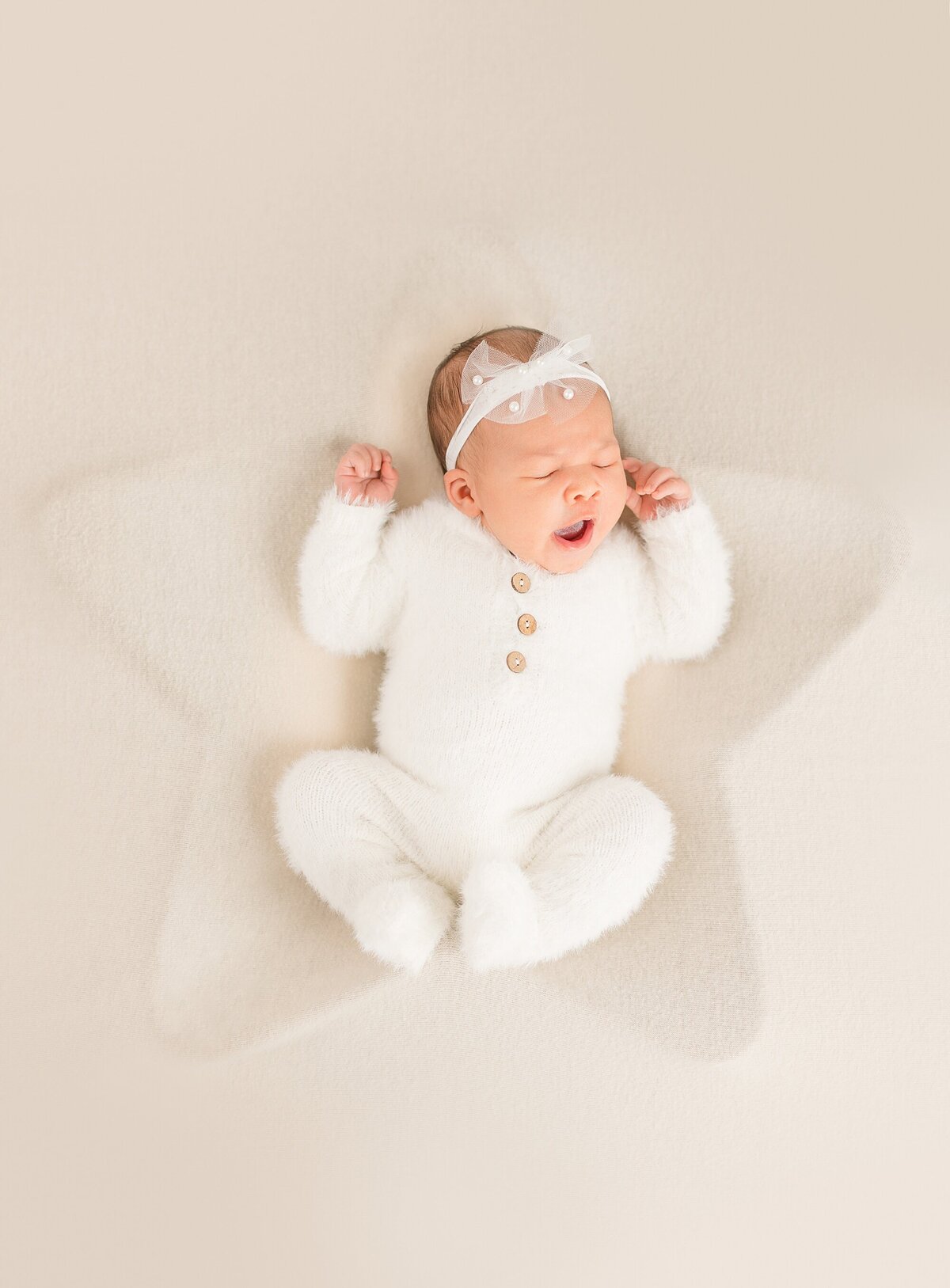 newborn images of a baby yawning in a star shaped bowl