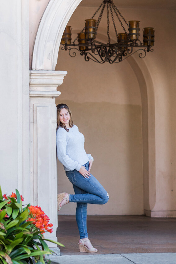 Senior girl leaning against arch in Balboa Park San diego