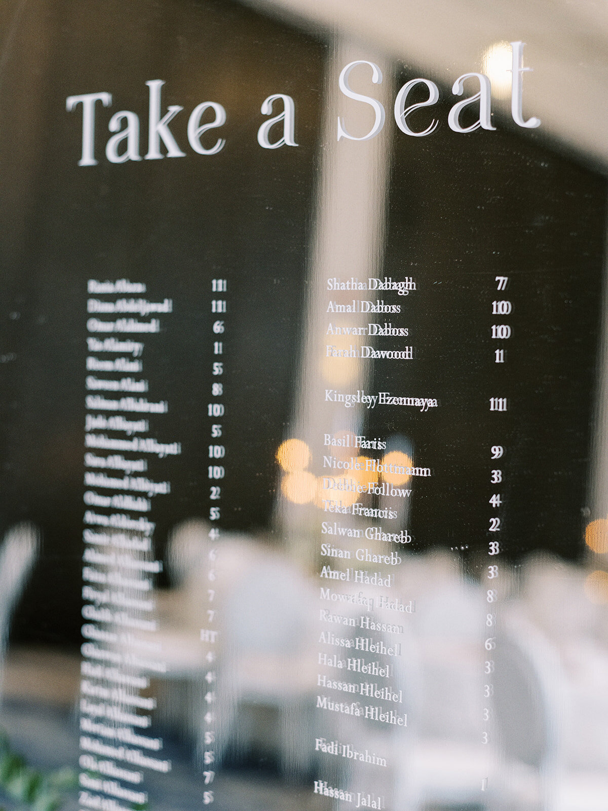 A seating chart for a classic Calgary wedding. The title "Take a Seat" is displayed at the top, followed by a list of names and corresponding table numbers.