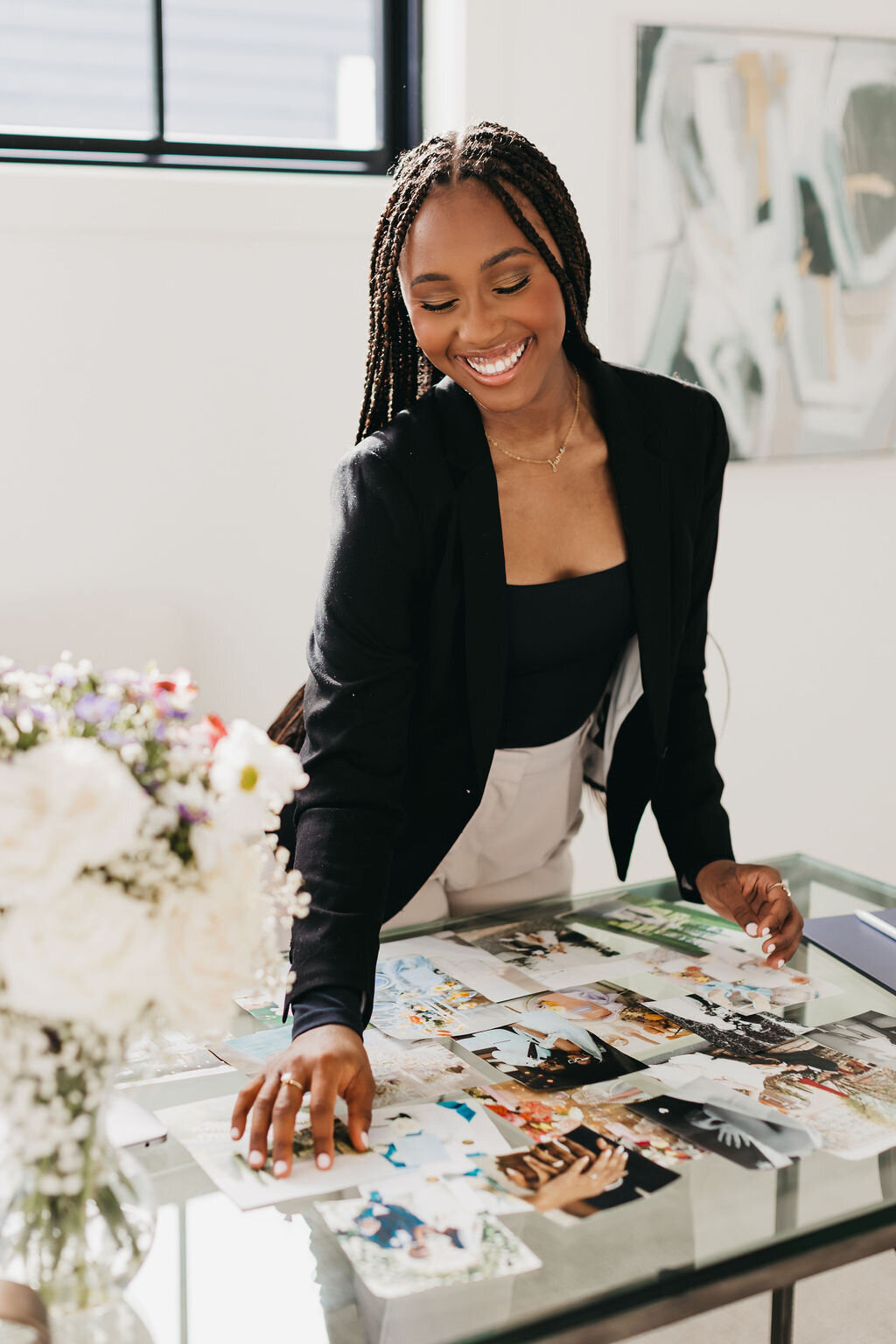 Juma Waganda in a black blazer arranging photos on a clear table