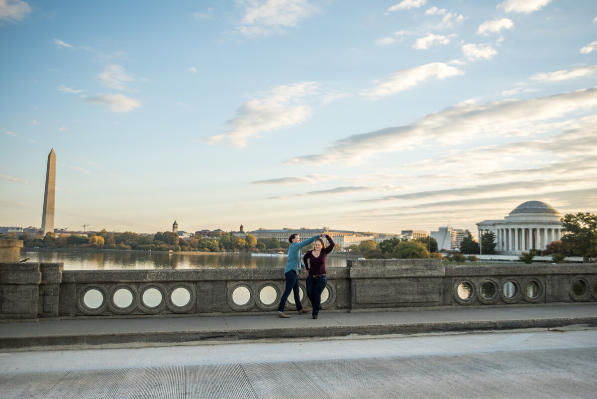A couple walks with each other across a bridge.