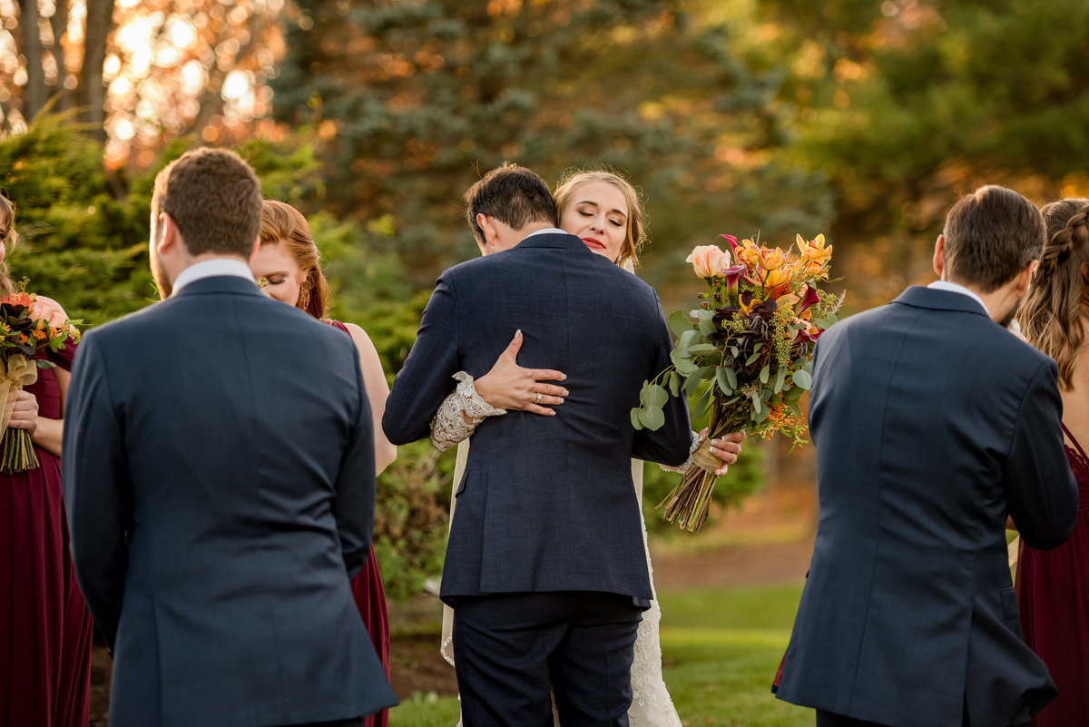 guests being hugged by newlyweds