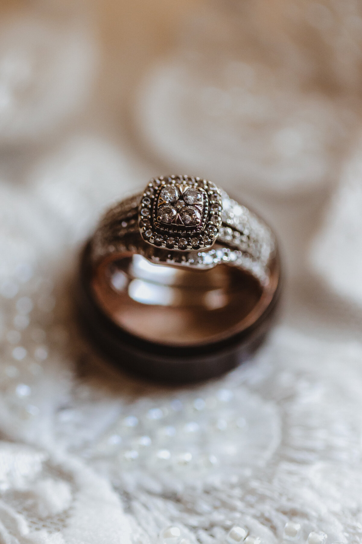 WEDDING RINGS HIS AND HERS ON WEDDING GOWN LACE