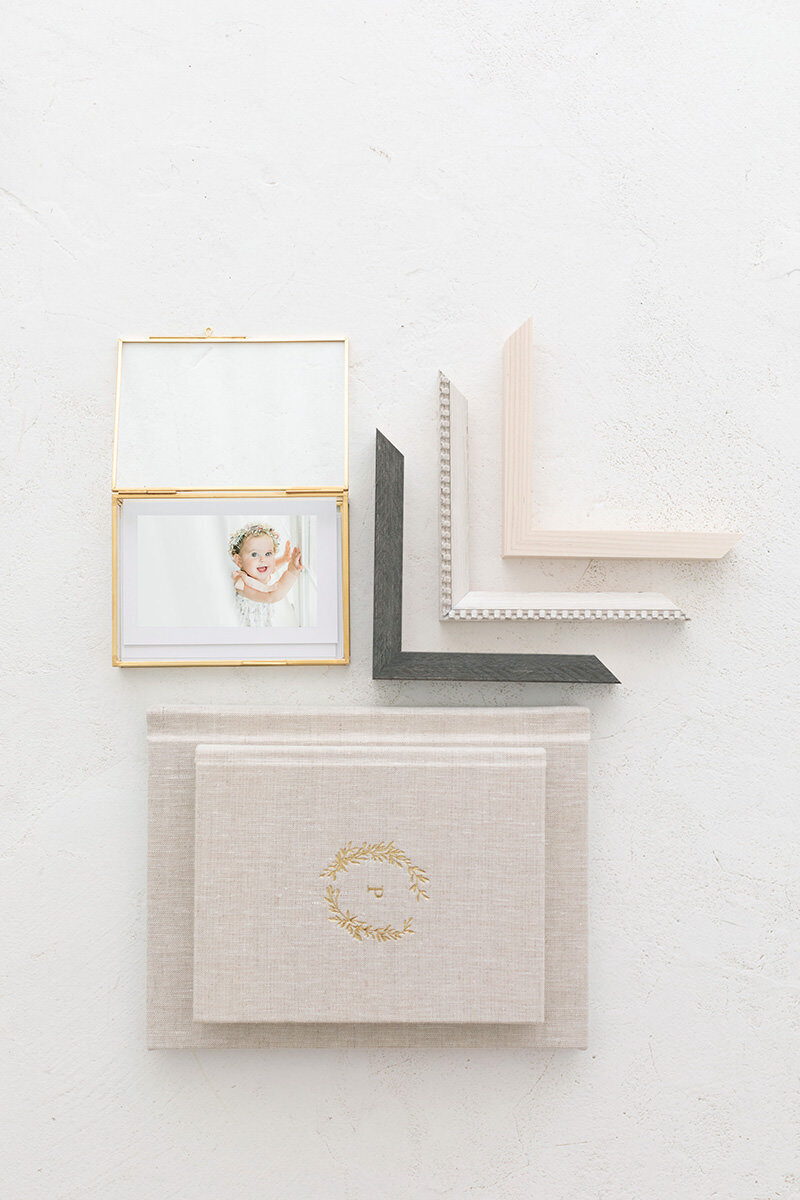Flat lay of heirloom photo products including albums, frames, and velvet boxes