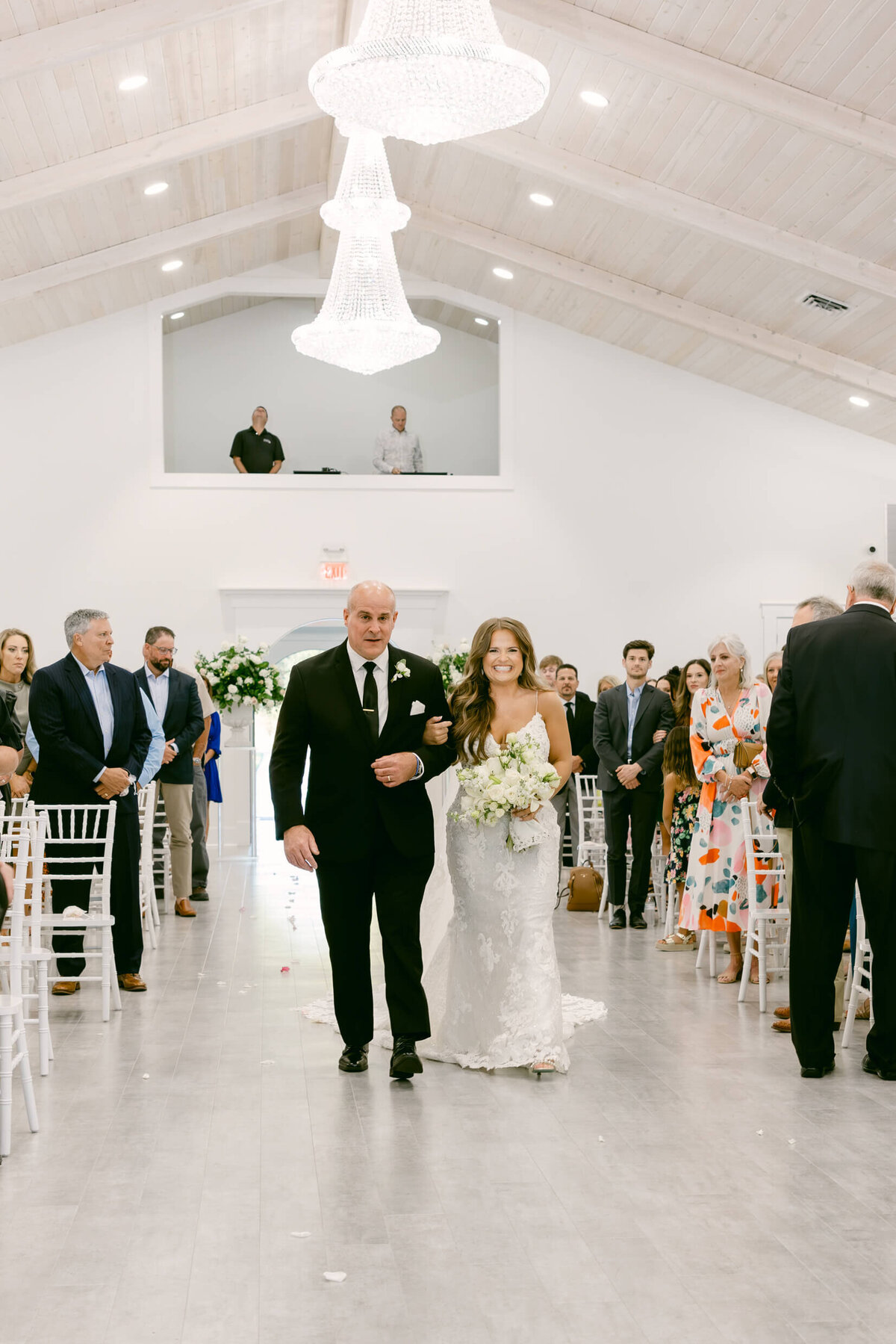 A wedding photo of a bride walking down the aisle with her father