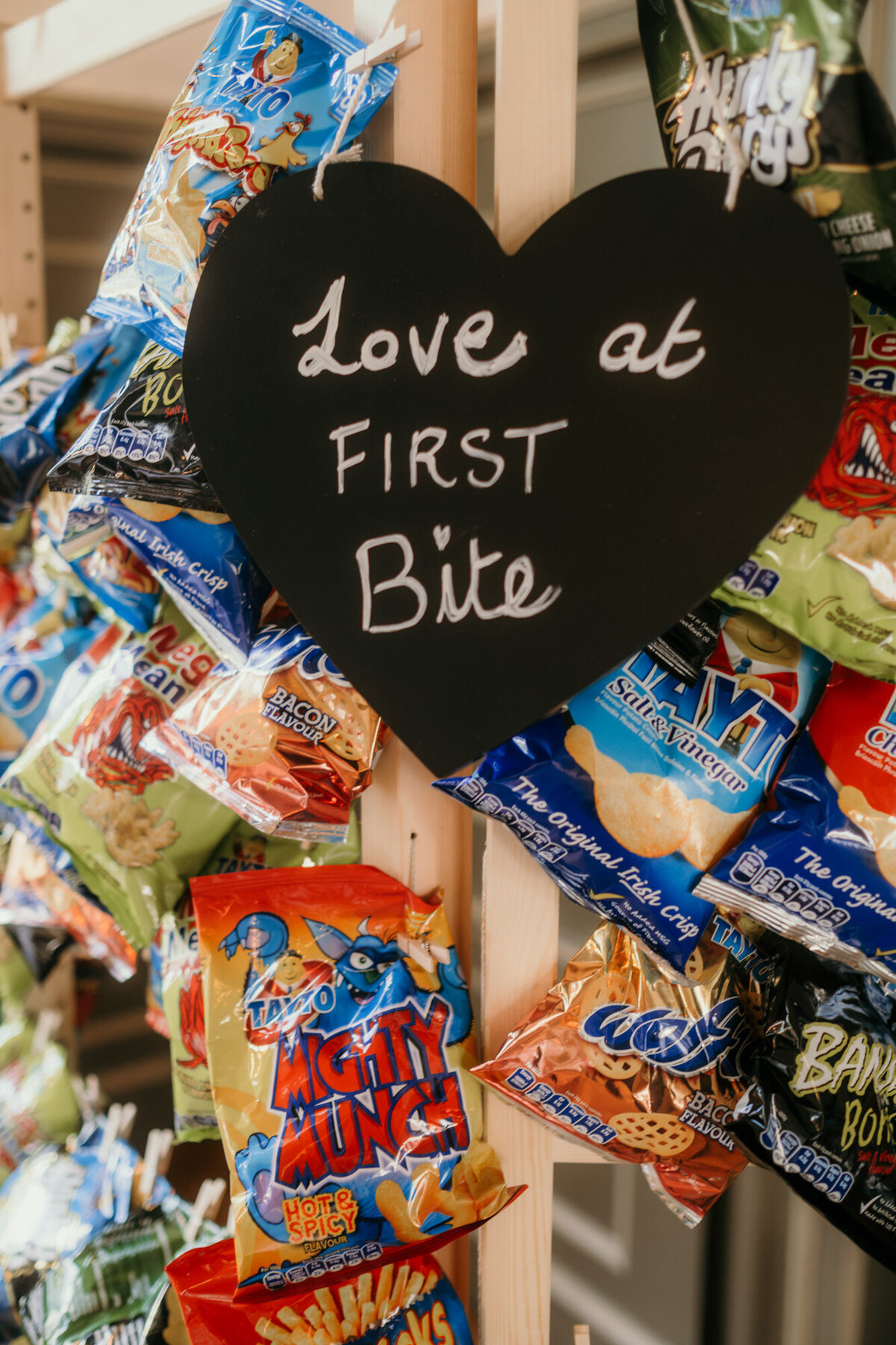 Das Chipsregal hat ein Tafelschild in Herzform mit der Aufschrift: Love at first bite.