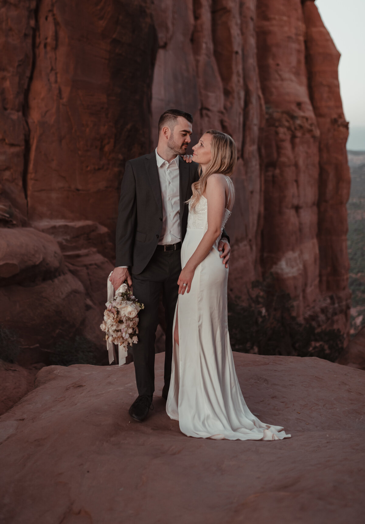 Bride fixing hair in wind before elopement vows Sedona taken by Kollar Photography