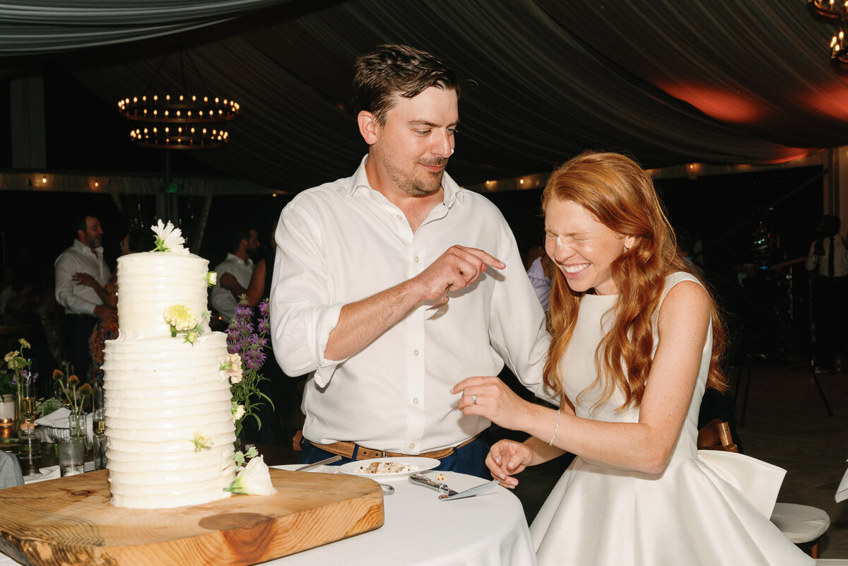 groom feeds bride at wilburton inn wedding cake