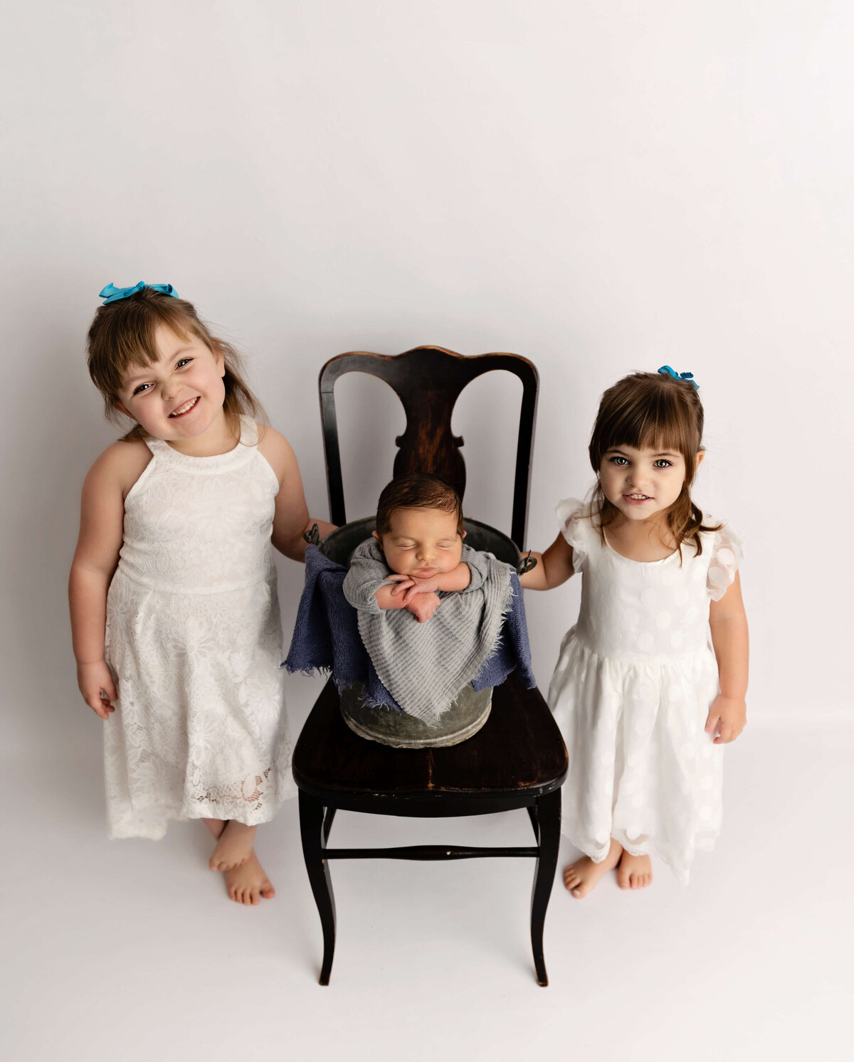 Newborn photo of a baby boy with sisters in an Erie Pa photography studio