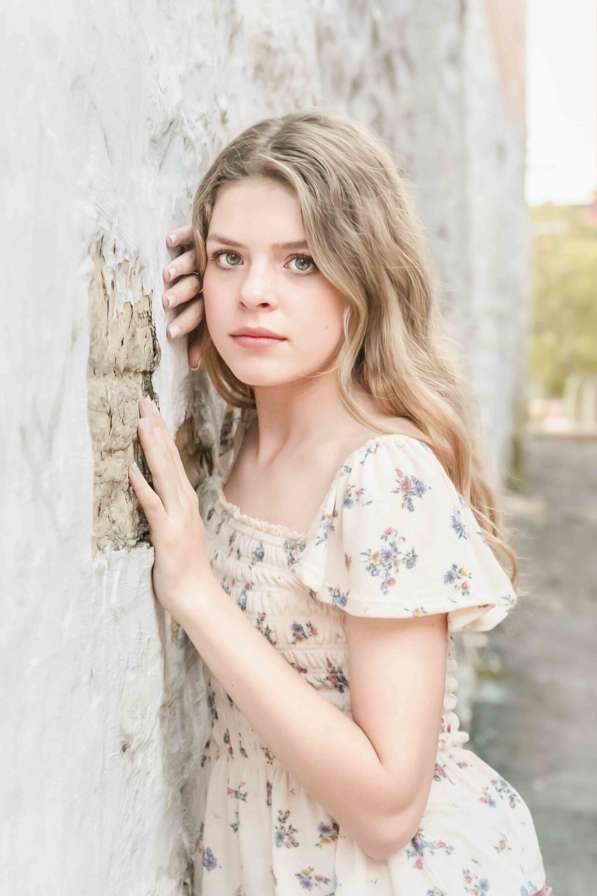 Teen girl leaning on a white brick wall
